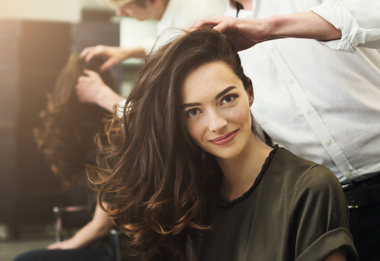 Woman sitting at beauty salon, making hairdo